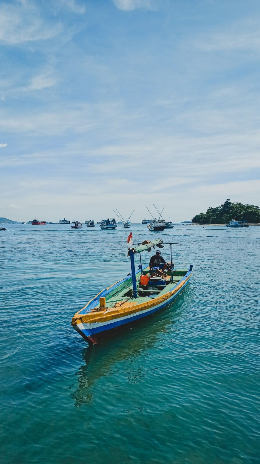 Aerial view of a fishing boat hauling its net at sea